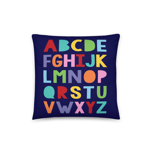 lphabet cushion cover in a mix of bright colours on dark blue background