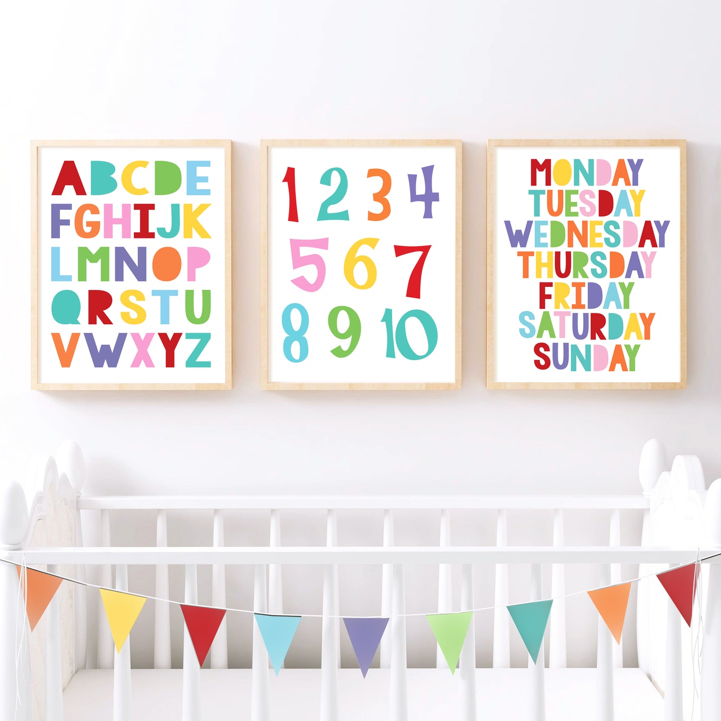 A set of three educational prints featuring a colourful uppercase alphabet, numbers 1-10 in a playful font, and the days of the week in a bold, rainbow colours creating a bright and cheerful nursery setting.