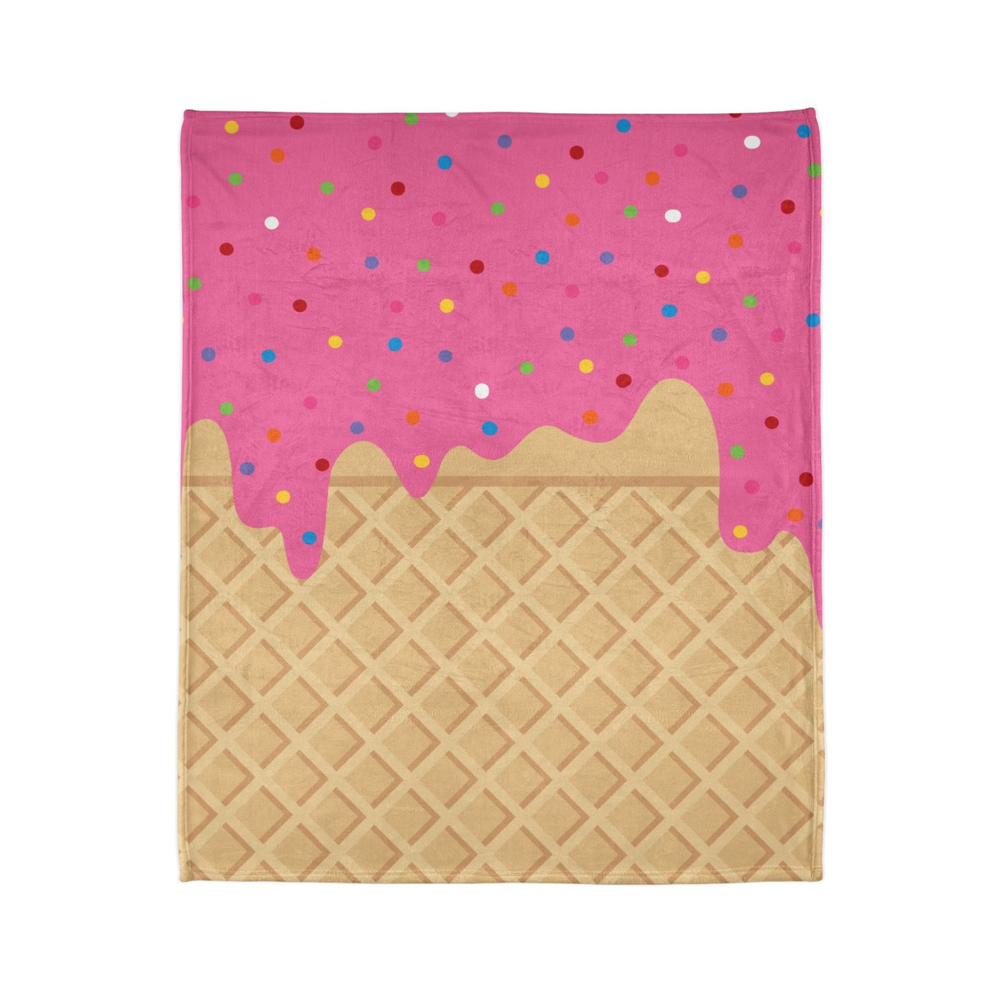 A blanket with a vibrant pink 'ice cream' design topped with colorful sprinkles, laid on a flat surface.