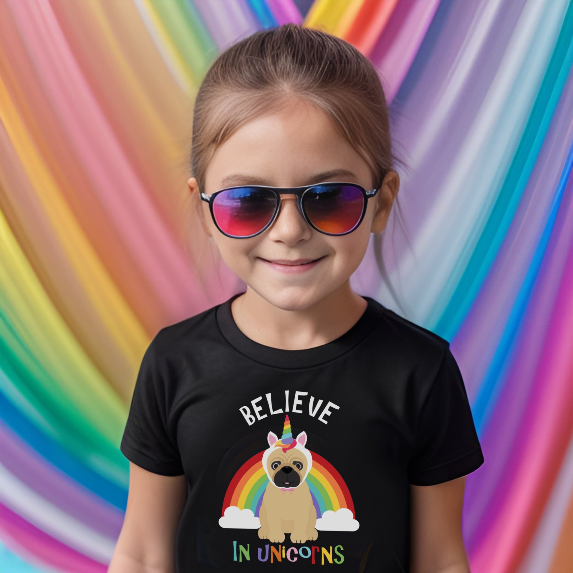 Girl in kids t-shirt with pug and unicorn rainbow design against a rainbow backdrop
