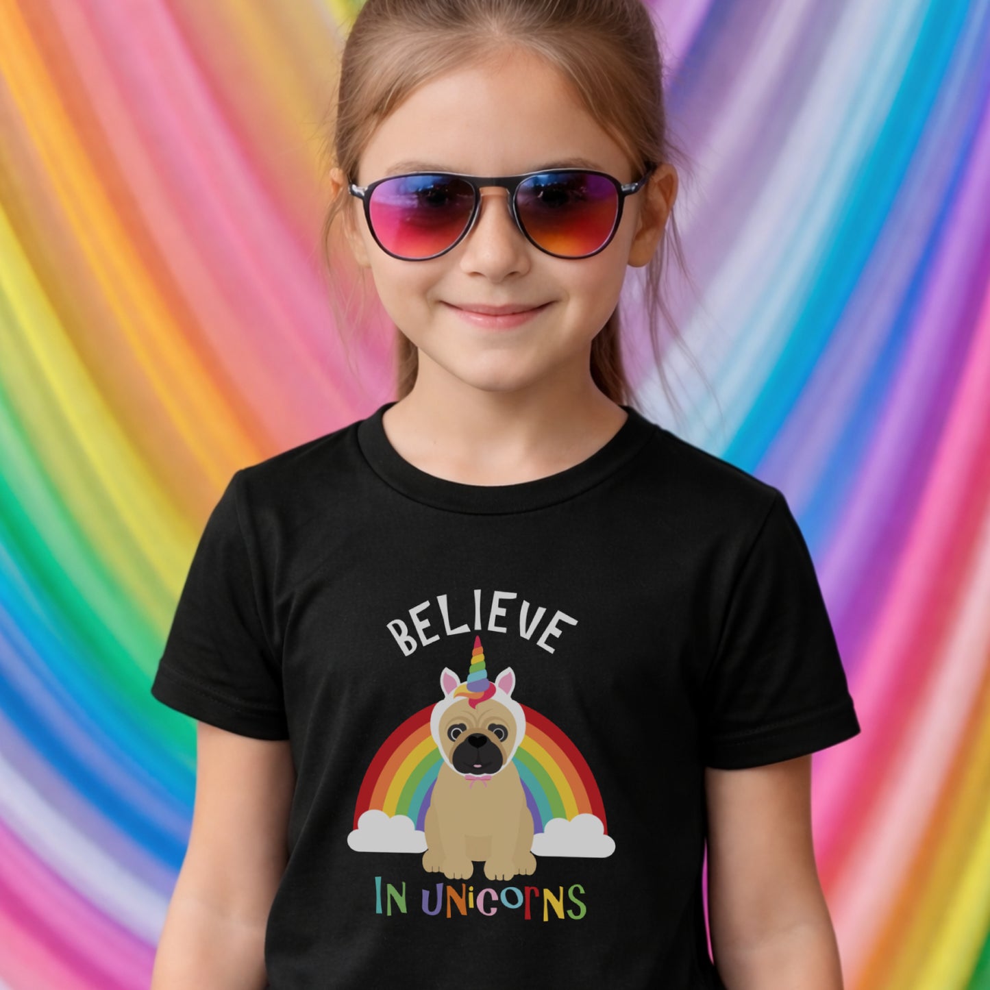Girl in kids t-shirt with pug and unicorn rainbow design against a rainbow backdrop
