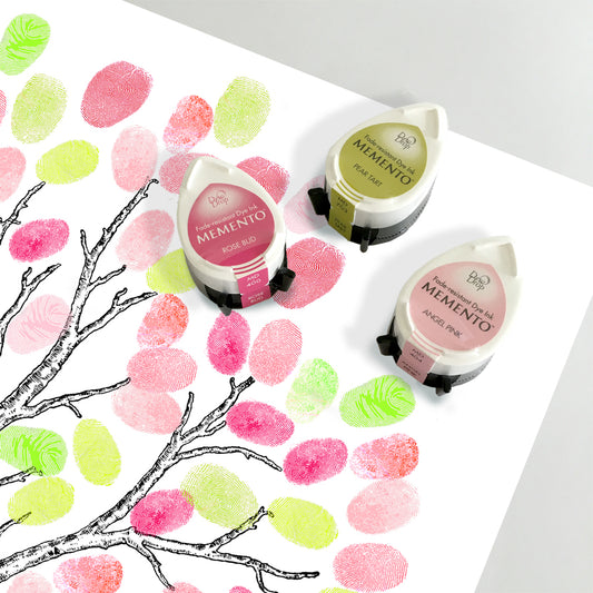 set of fingerprint tree ink pads, two pink and one green sitting on a fingerprint guestbook tree