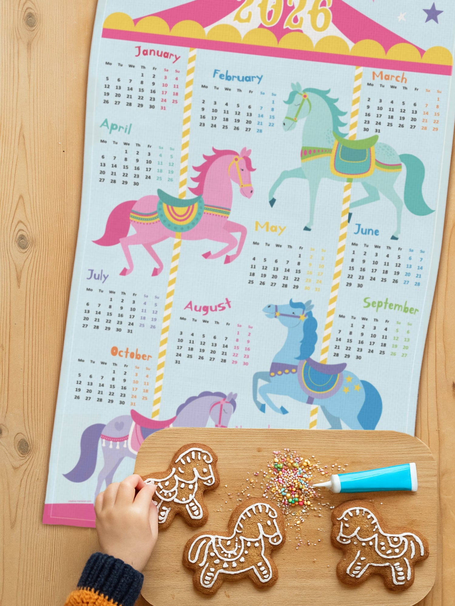 Tea towel with carousel horse design on kitchen table with horse cookies