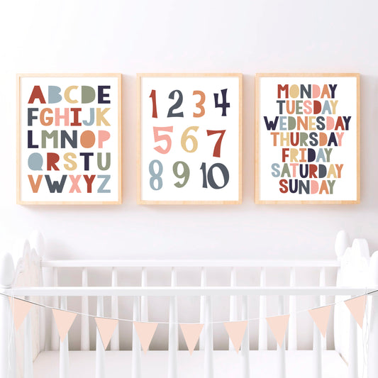 set of three with the ABCs, numbers and days of the week in earthy tones over cot