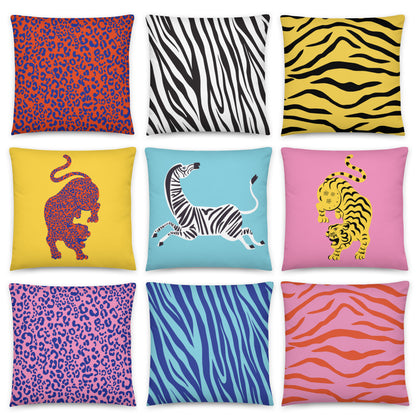 Collection of colourful Wild Things animal print cushion covers featuring tiger, zebra and leopard designs in bold pink, yellow, blue, orange and black colour combinations arranged in a grid.