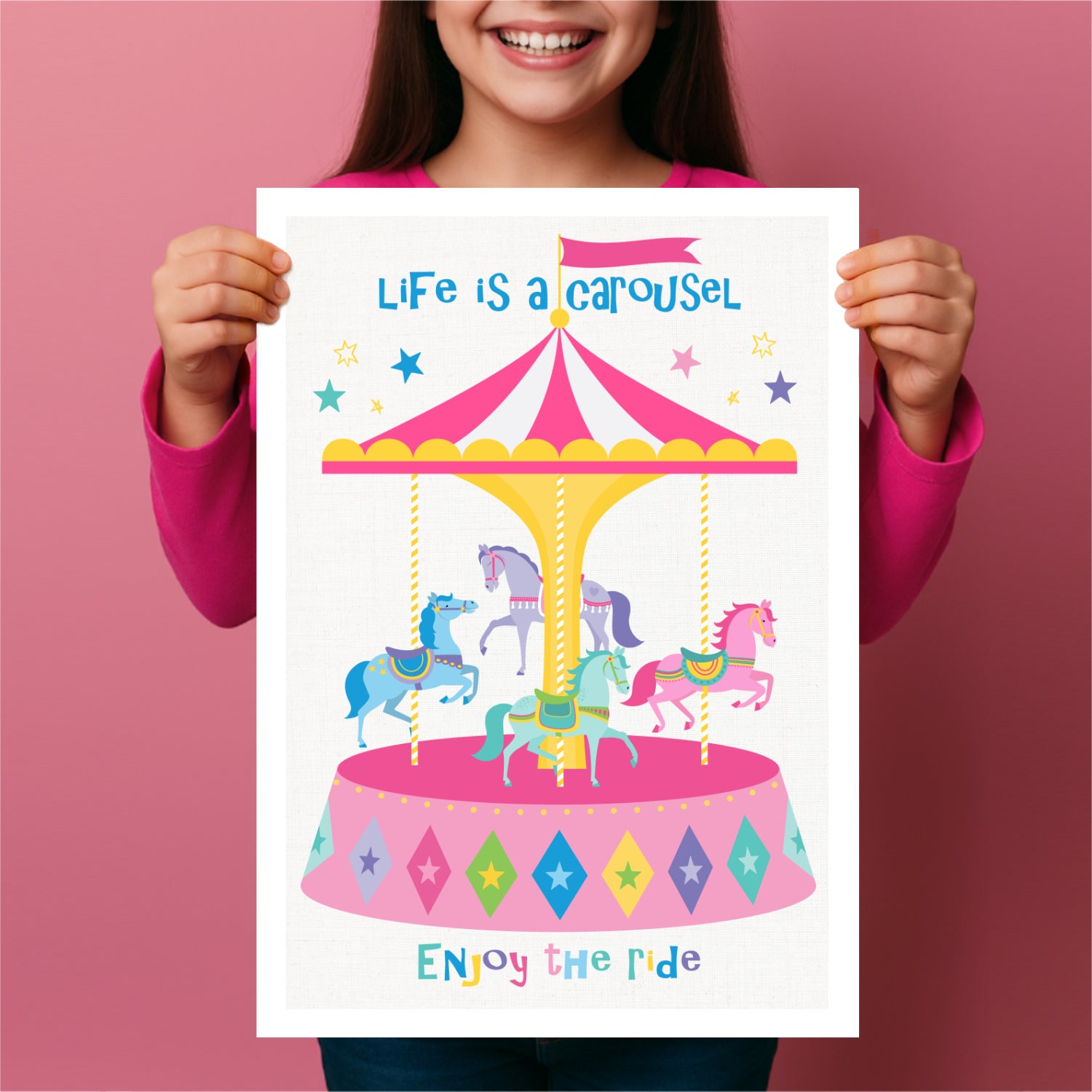 Child holding a poster with a colorful carousel illustration and text on a pink background