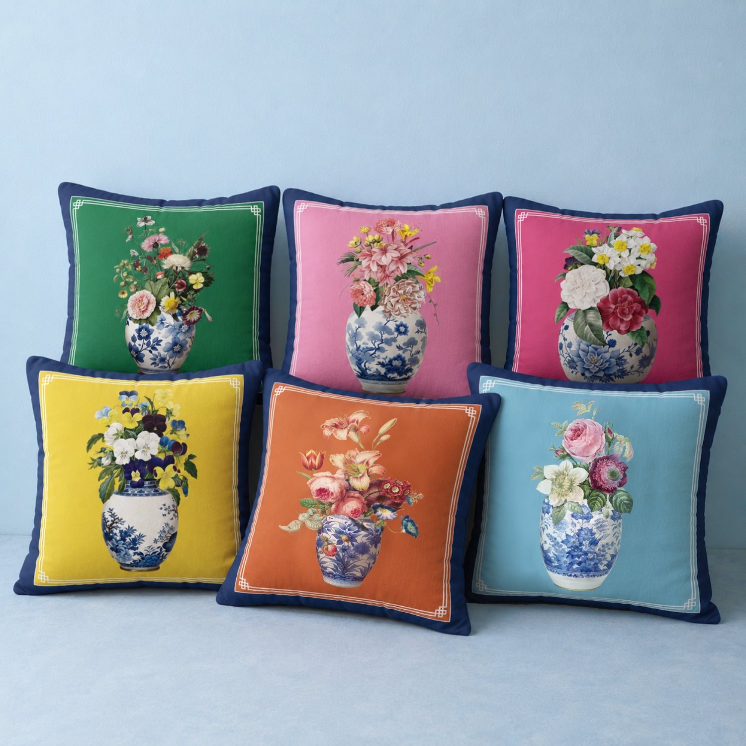 Colourful floral decorative cushions arranged in a modern home décor mockup with blue bordered square pillows, vibrant botanical vase designs 