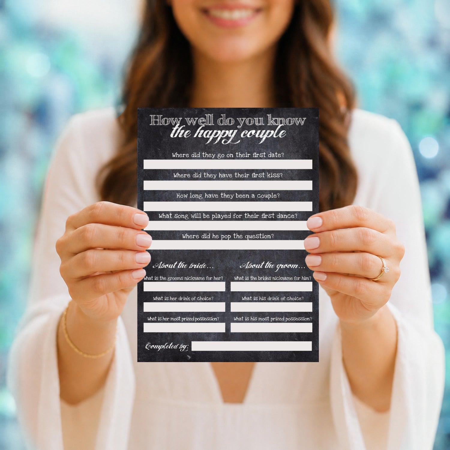 Person holding a card titled 'How well do you know the happy couple' at a wedding reception