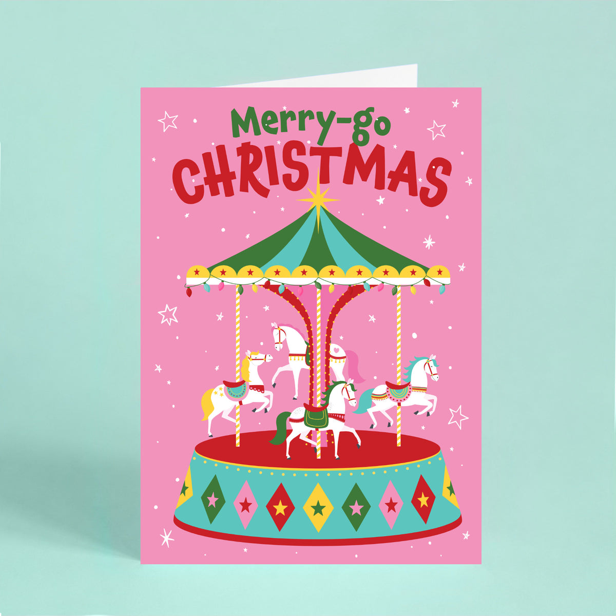 Colourful Christmas card featuring a festive carousel with white horses, Christmas lights and the words “Merry-go Christmas” on a pink background.