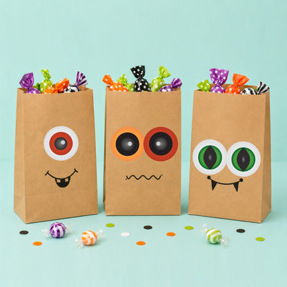 Printable Halloween monster eye party circles used on DIY treat bags filled with candy for Halloween party favours