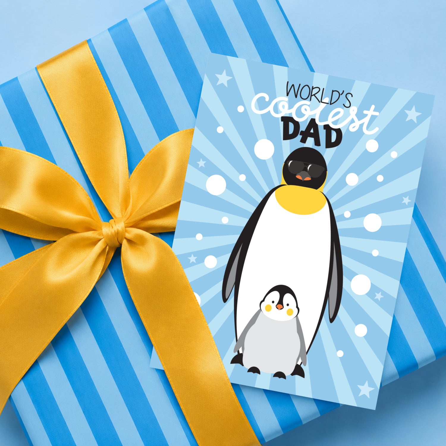 World's Coolest Dad penguin Father's Day card displayed with wrapped gift for dad