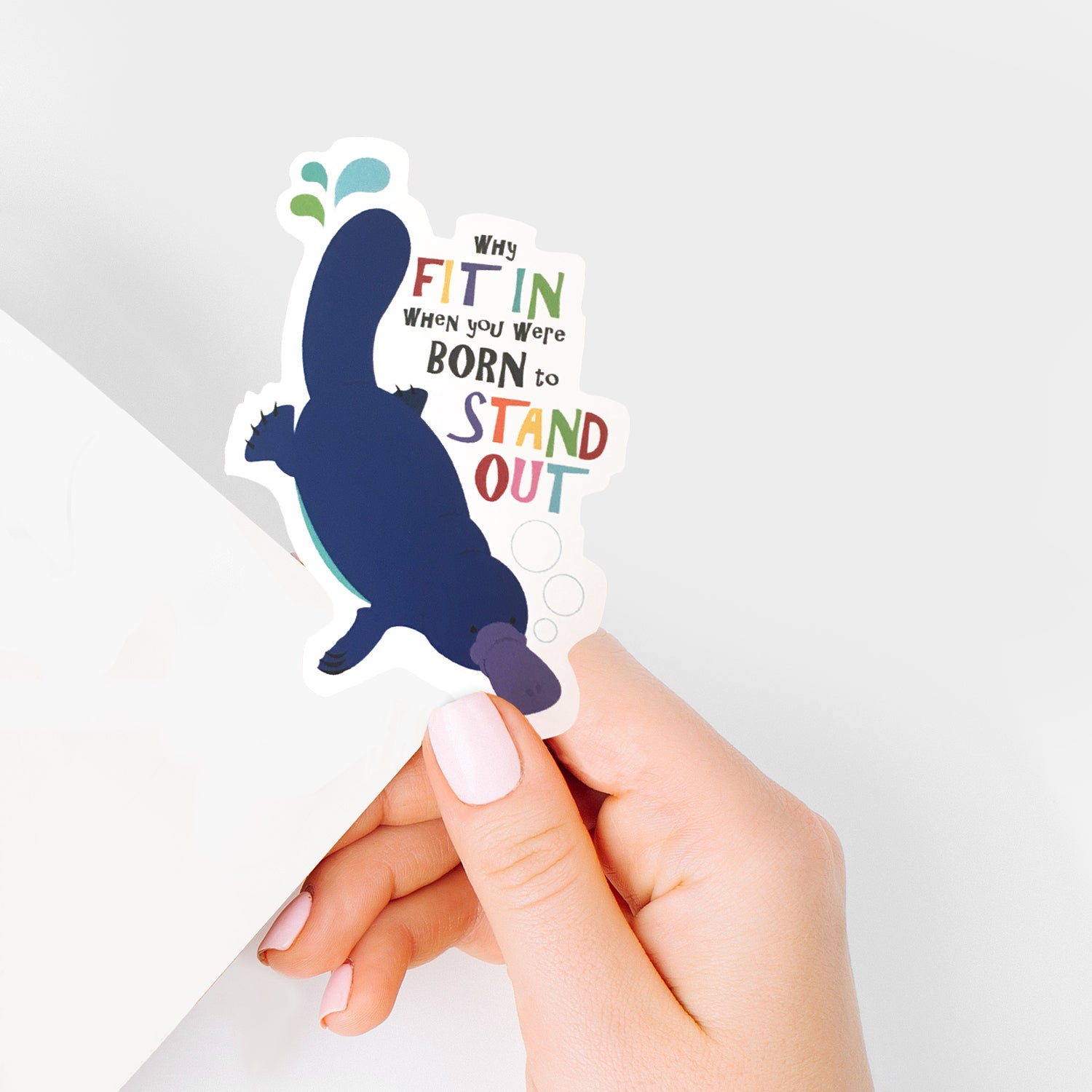 hand holding platypus sticker with Why fit in when you were born to stand out.