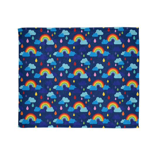 vibrant throw blanket with a design that features colourful rainbows, playful raindrops, and fluffy clouds set against a deep blue background