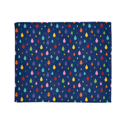 A large throw blanket with a dark navy blue background featuring a playful pattern of colorful raindrop shapes in various sizes and colors, including red, yellow, green, pink, and blue. 