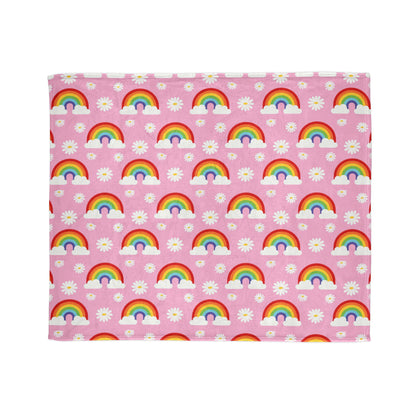 super-soft, cozy blanket features a fun and cheerful pattern of rainbows, clouds, and daisies on a pretty pink background