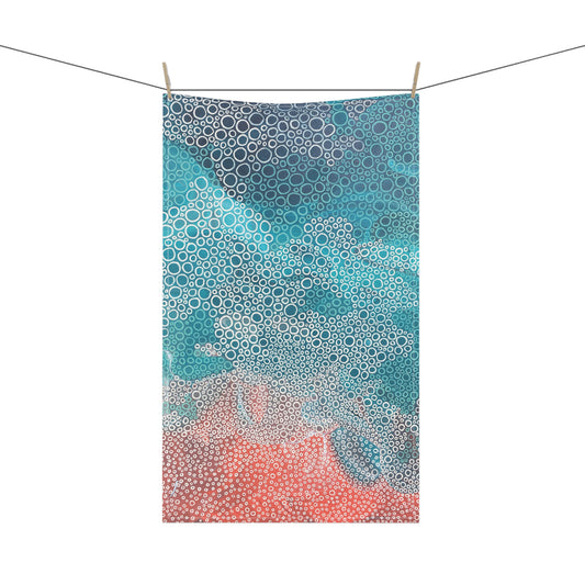 striking tea towel, featuring a soothing mix of seafoam turquoises, blues, and coral tones