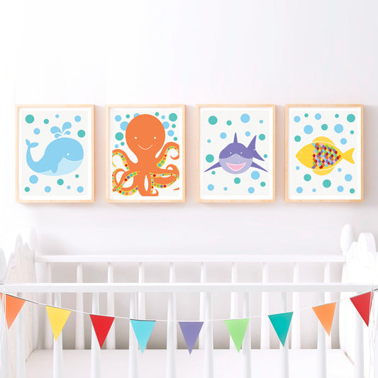 set of colourful sea-themed nursery art prints above a kids cot