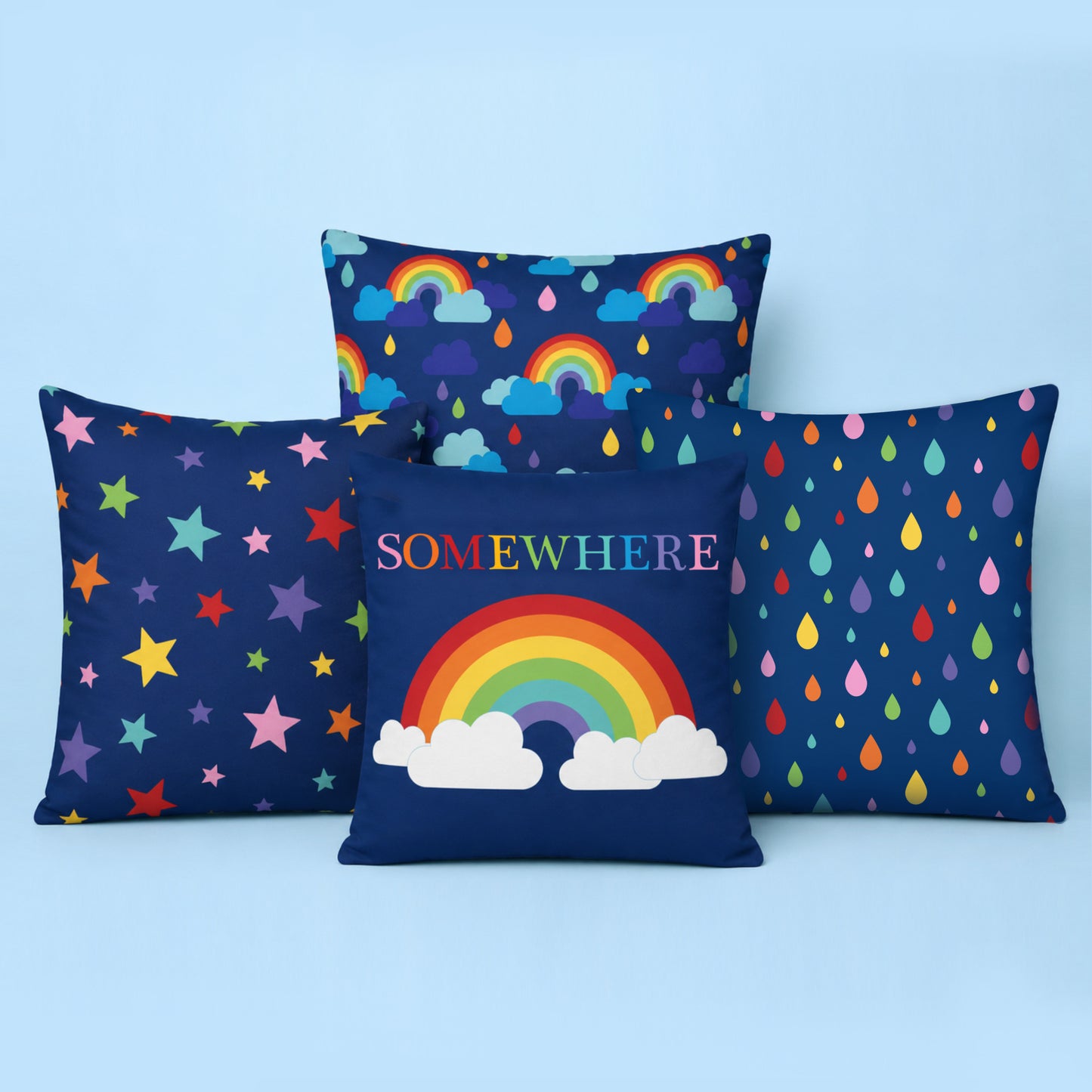 Set of four colourful rainbow themed cushion covers styled together on a light blue studio background featuring a Somewhere Over the Rainbow cushion, rainbow rain clouds, colourful raindrop pattern and multicoloured stars.