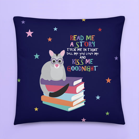 cushion cover is decorated with a little possum sitting on a stack of books with the words 'Read me a story, tuck me in tight, tell me you love me and kiss me goodnight' 