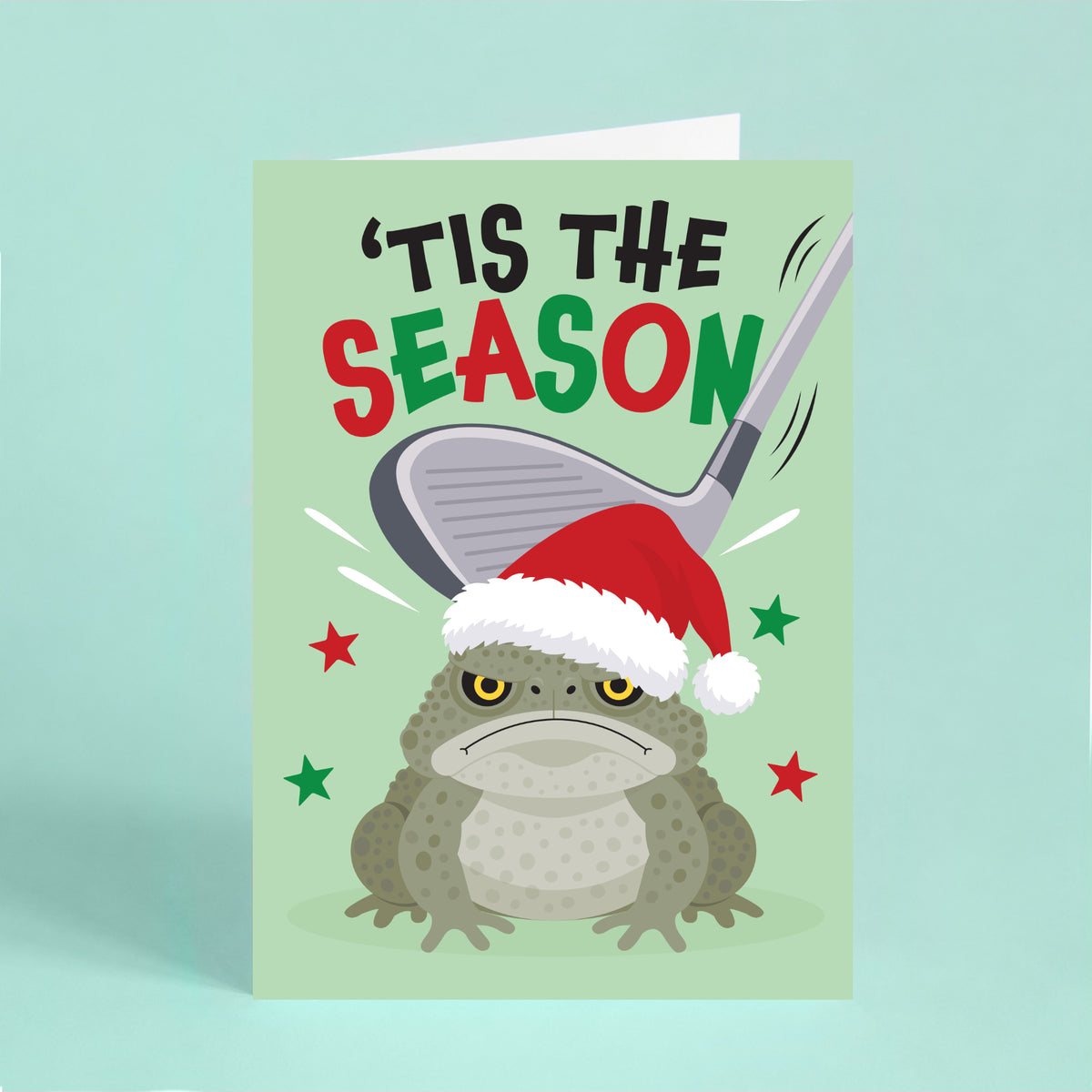 Funny cane toad Christmas card featuring a grumpy toad in a Santa hat with a golf club overhead and the words “’Tis the Season”.
