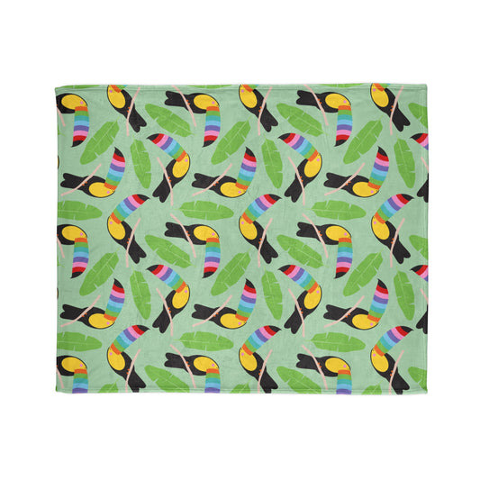 vibrant throw blanket, featuring a playful pattern of colourful toucans perched among lush green leaves on a mint background