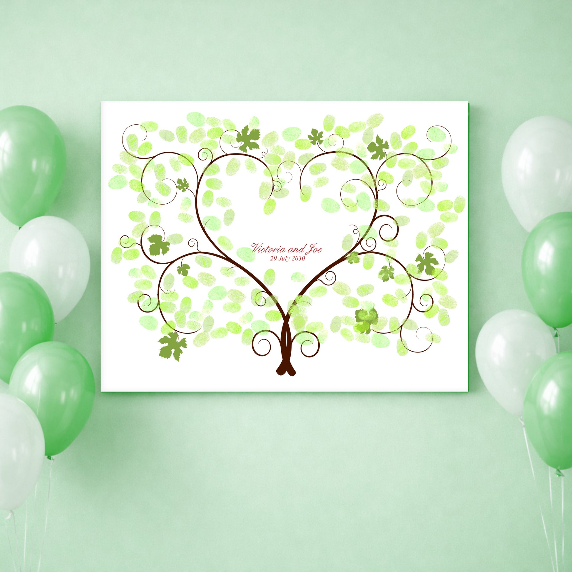 Decorative heart shaped grape vine design guest book poster with green leaves on a white background, surrounded by green and white balloons.