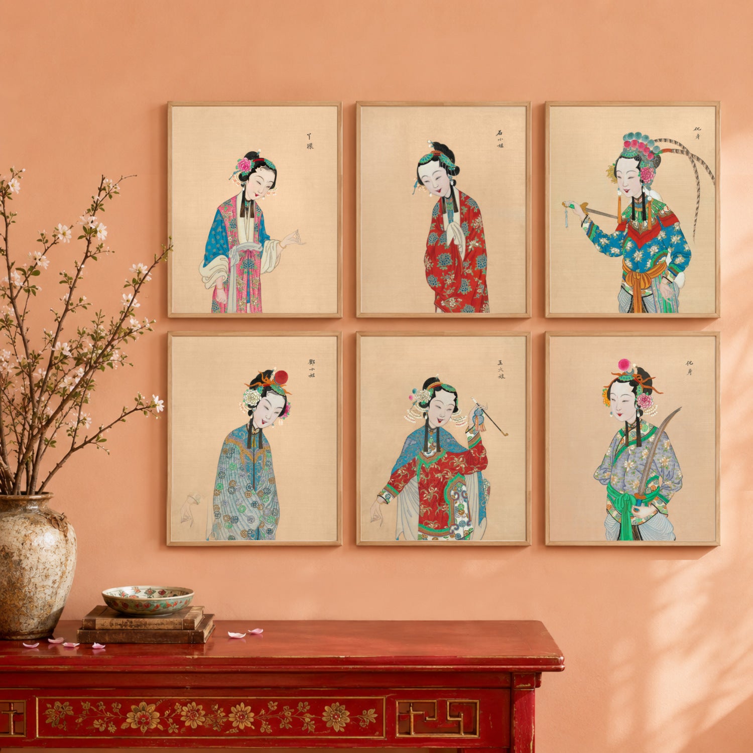 Six vintage Chinese Peking Opera lady art prints arranged as a gallery wall against a soft peach apricot background with colourful traditional costume portraits and chinoiserie inspired styling.