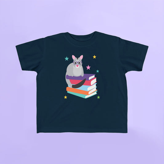 Navy t-shirt with a graphic of a possum on books and stars on a light purple background
