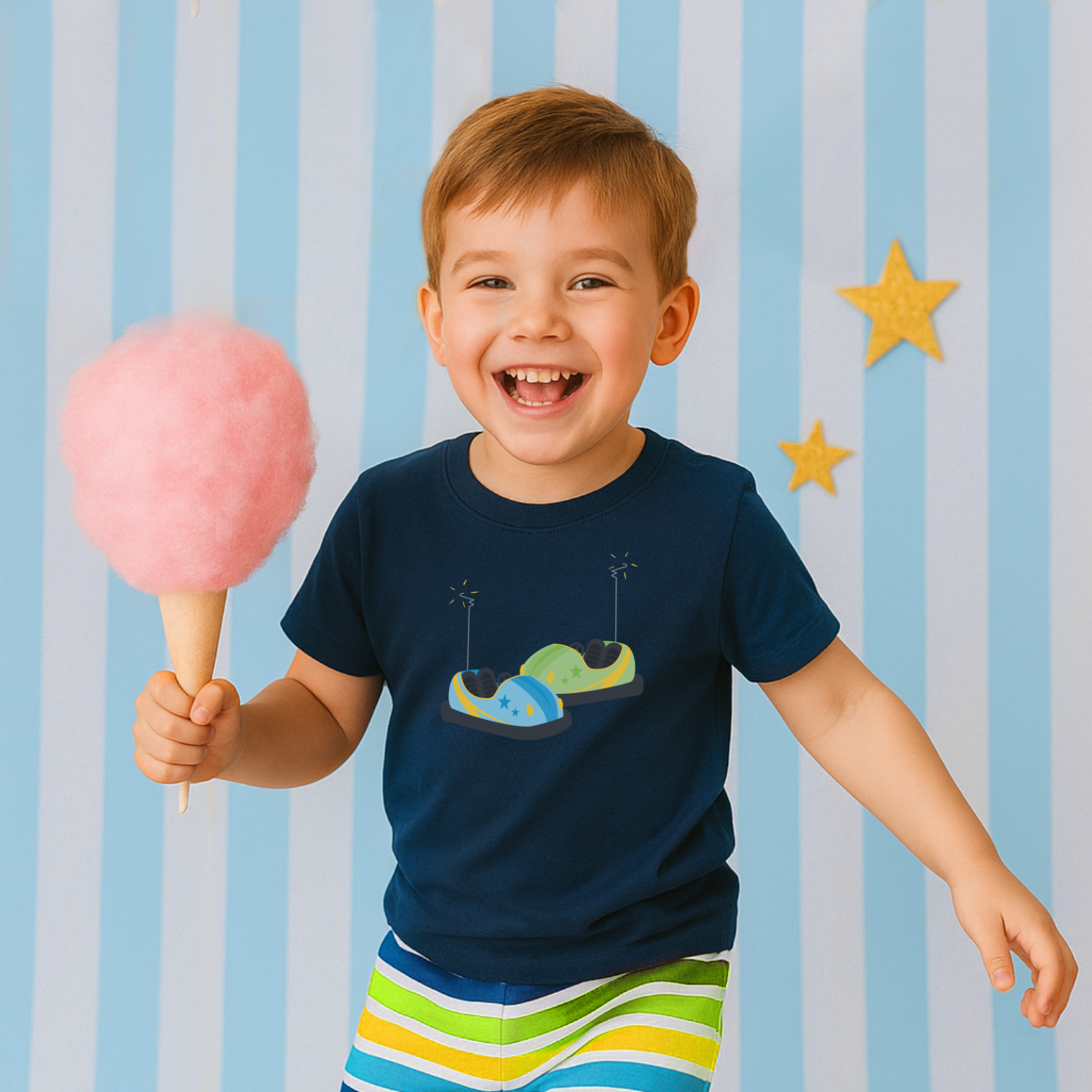 Child holding cotton candy wearing a bumper car t-shirt design, against a striped blue and white background with yellow stars.