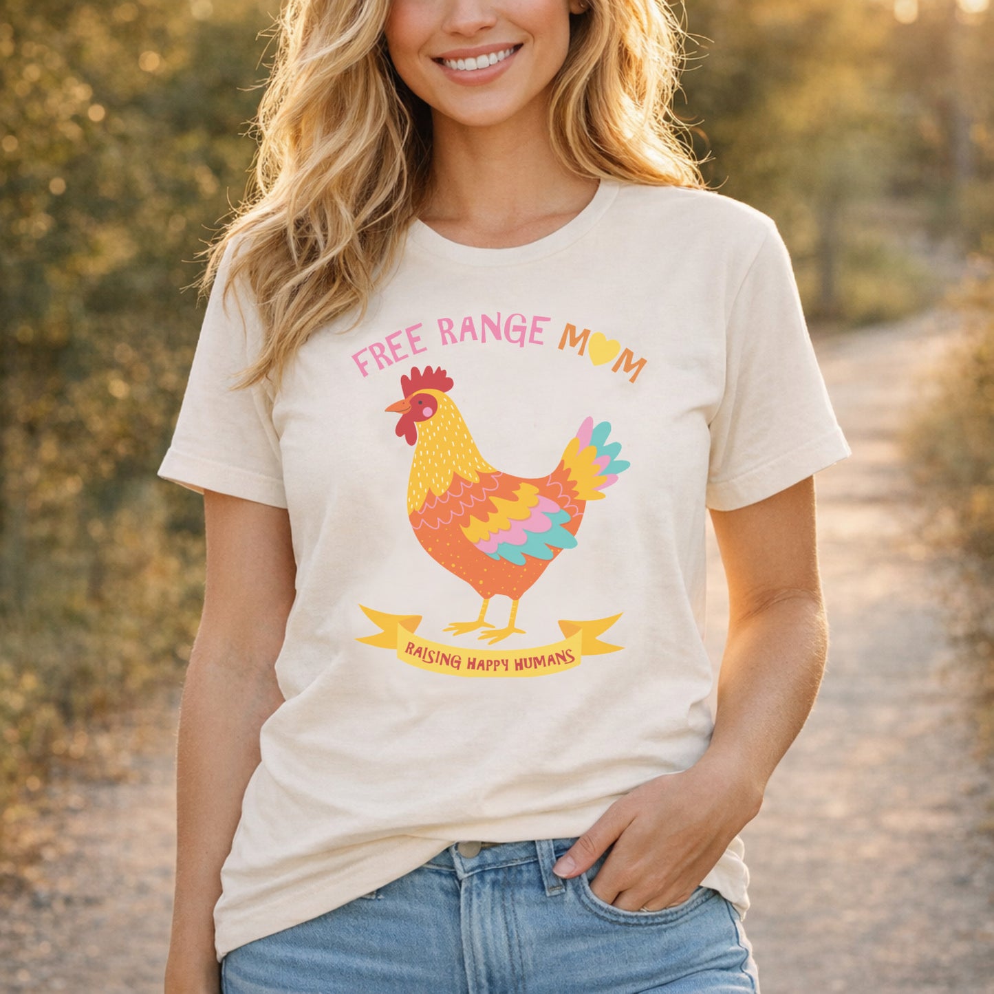 Woman wearing Free Range Mum t shirt outdoors in natural light, styled casually with denim and featuring colourful chicken illustration and motherhood slogan
