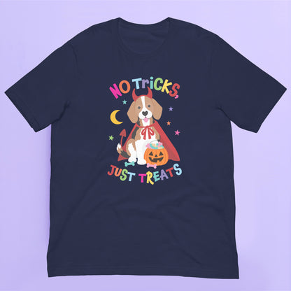 A navy blue short-sleeve Halloween t-shirt with a colorful graphic of a dog dressed as a devil wearing a cape and holding a pumpkin, with the text 'NO TRICKS JUST TREATS' in a playful multicolor font