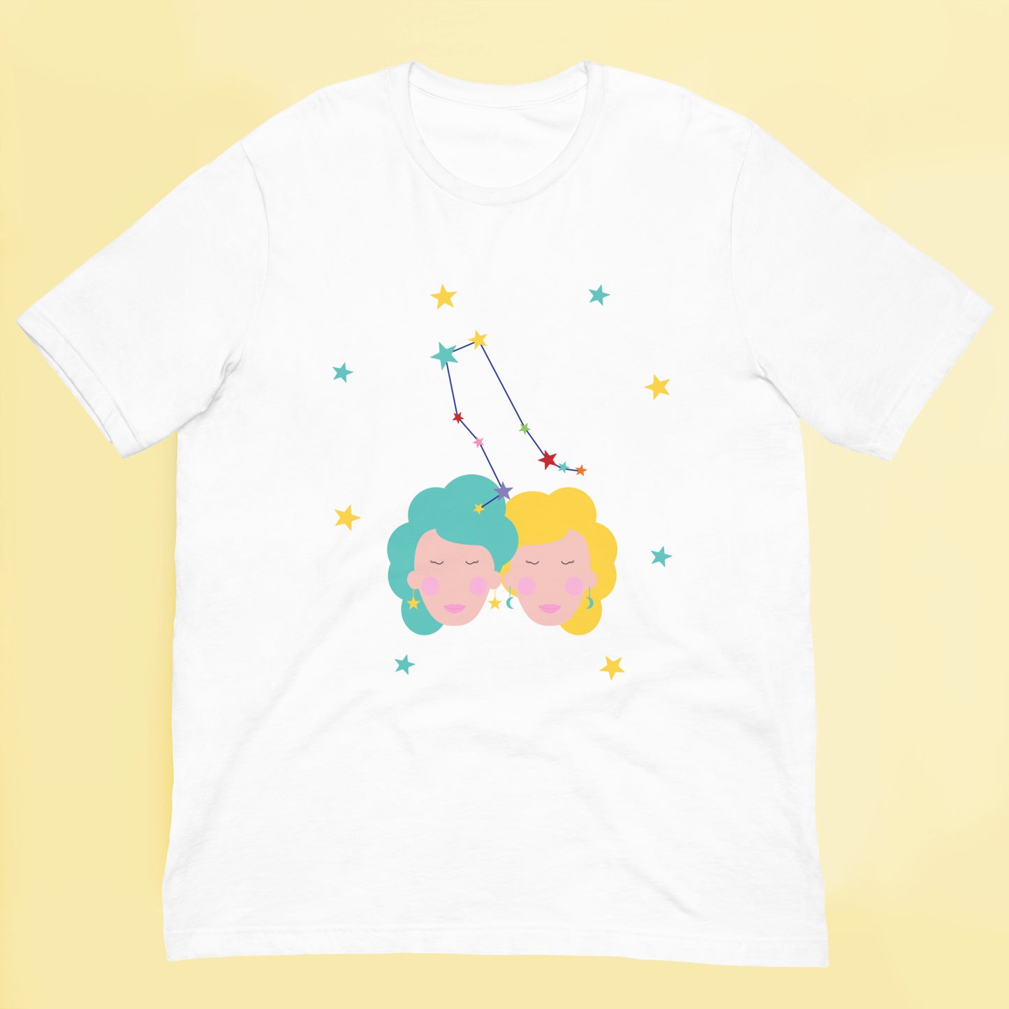White t-shirt with colorful graphic of gemini two faces and a constellation on a yellow background