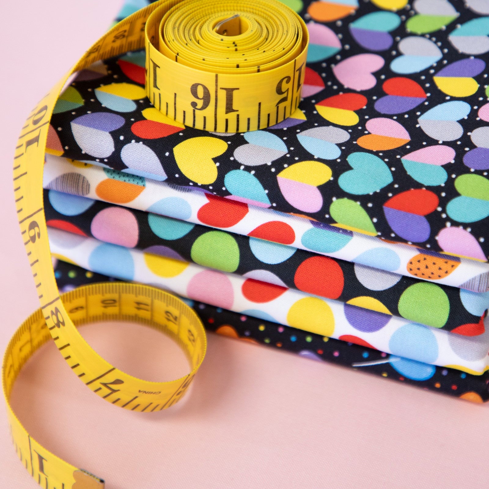 Colorful fabric ready to license with a yellow measuring tape on a pink background