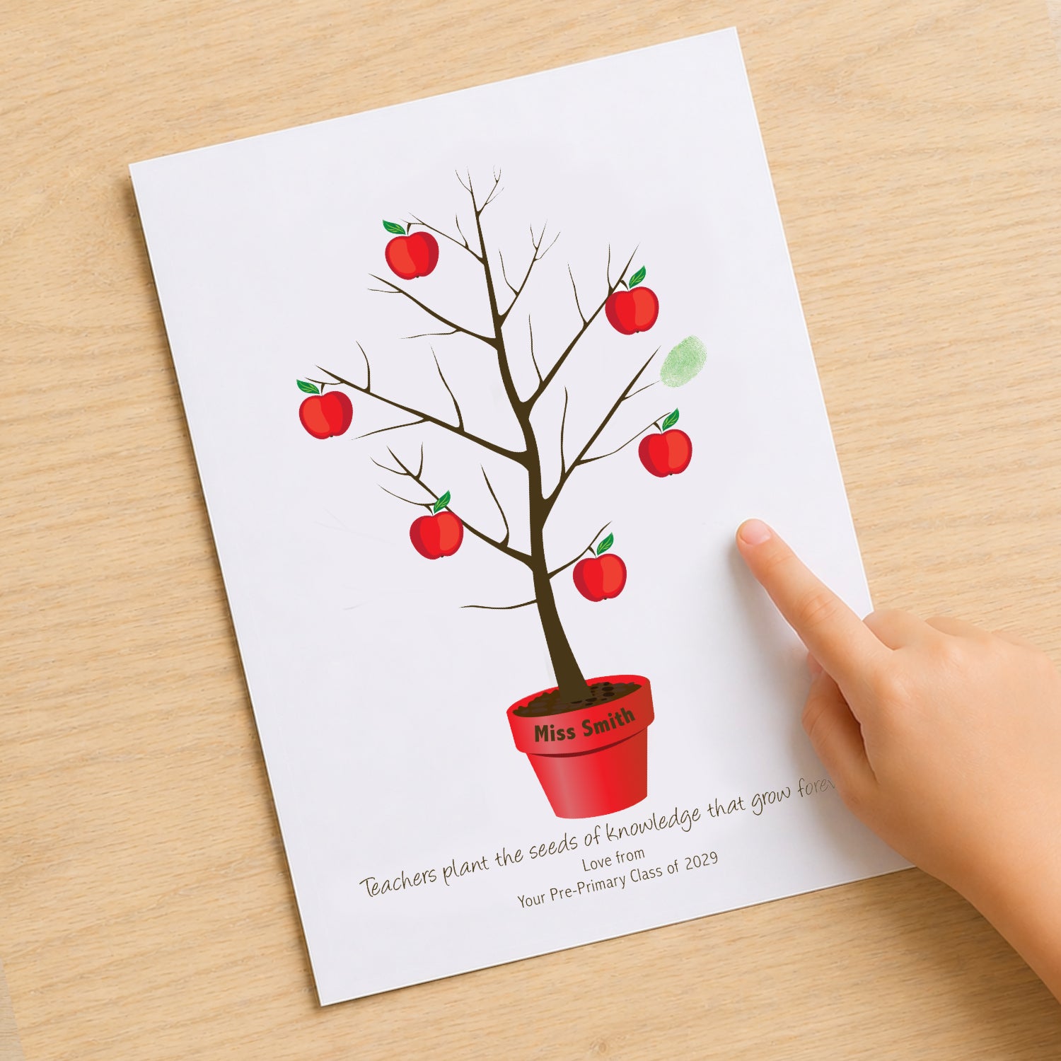 Teacher fingerprint tree print on desk with child hand adding fingerprint, personalised teacher gift idea