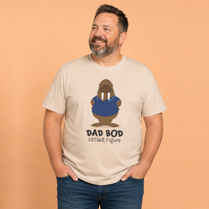 Smiling man wearing a beige graphic t-shirt featuring a walrus in a blue polo shirt and the humorous phrase "Dad Bod Father Figure". Funny Father's Day gift t-shirt for dads.