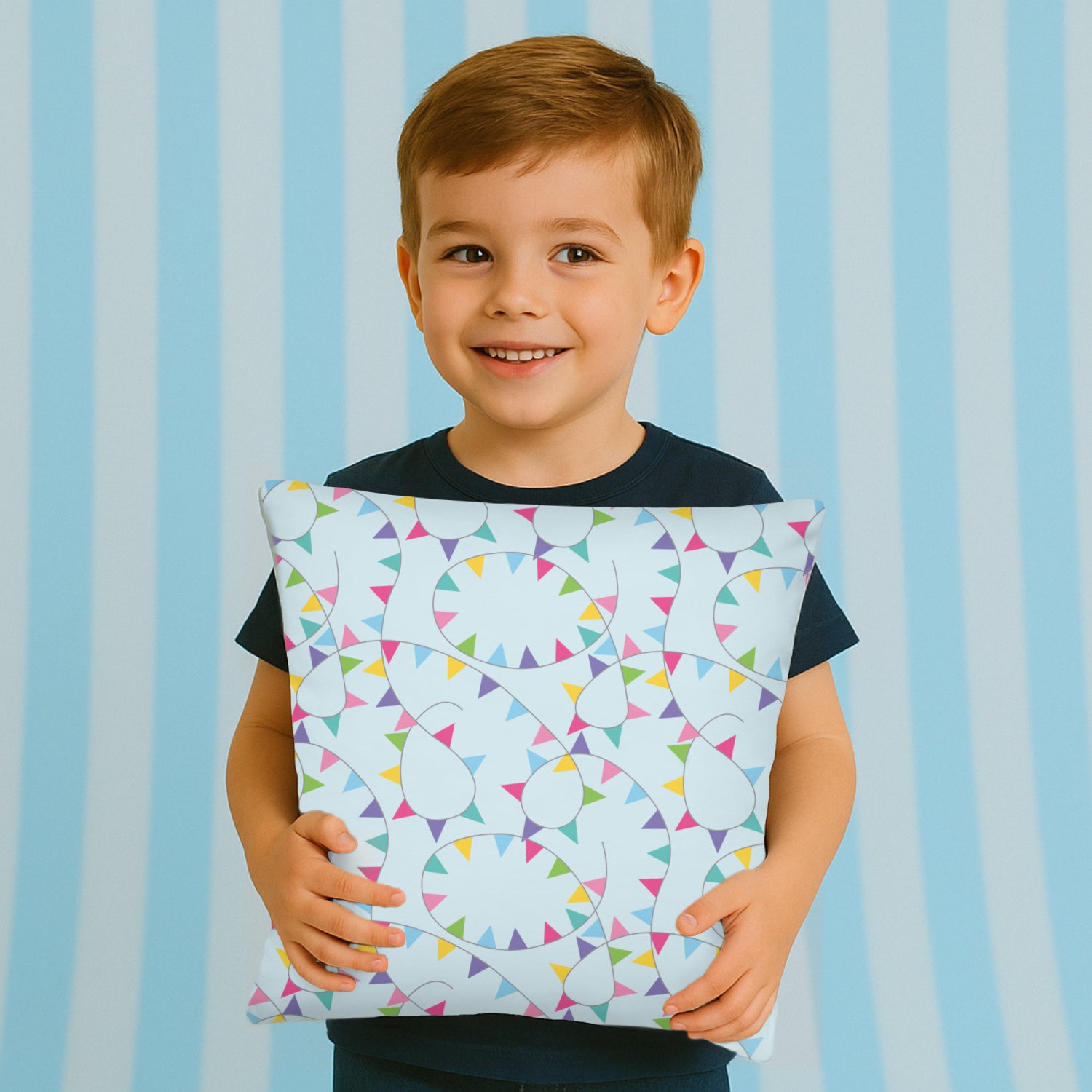 Child holding a pillow with colorful bunting pattern against a striped background
