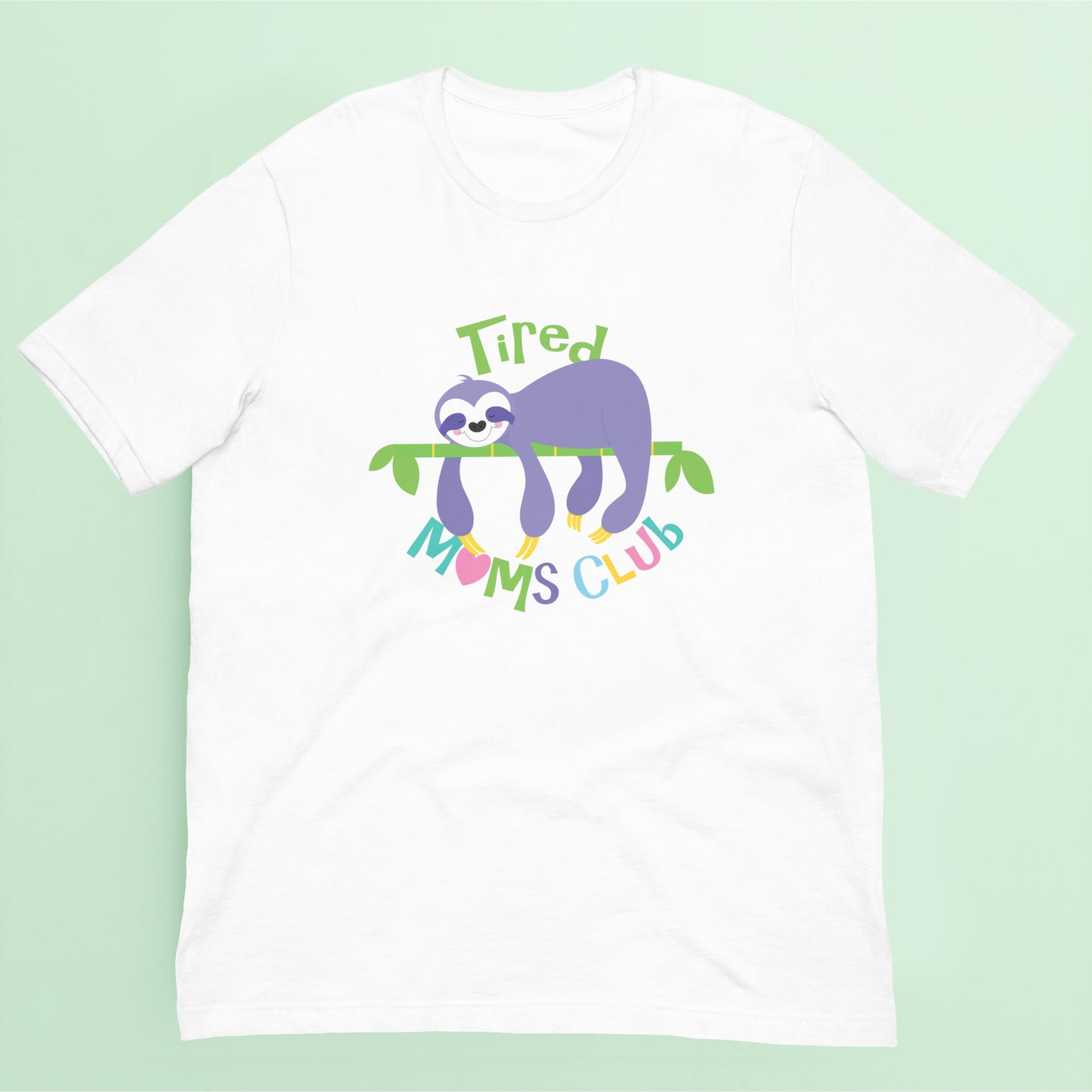 White t-shirt with a sloth graphic and 'Tired Moms Club' text on a light green background