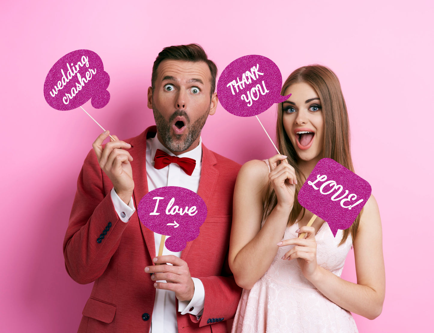 couple at a wedding with pink glitter effect wedding photo booth props