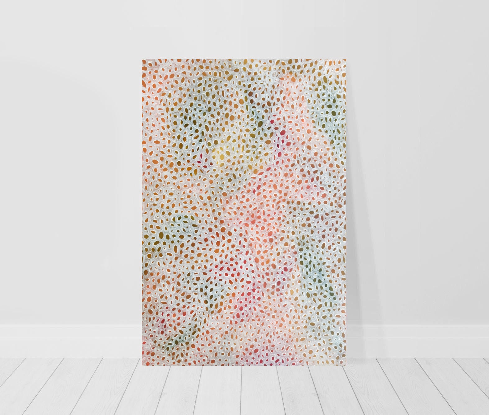 print leaning against wall of abstract painting in shades of peach, green and brown