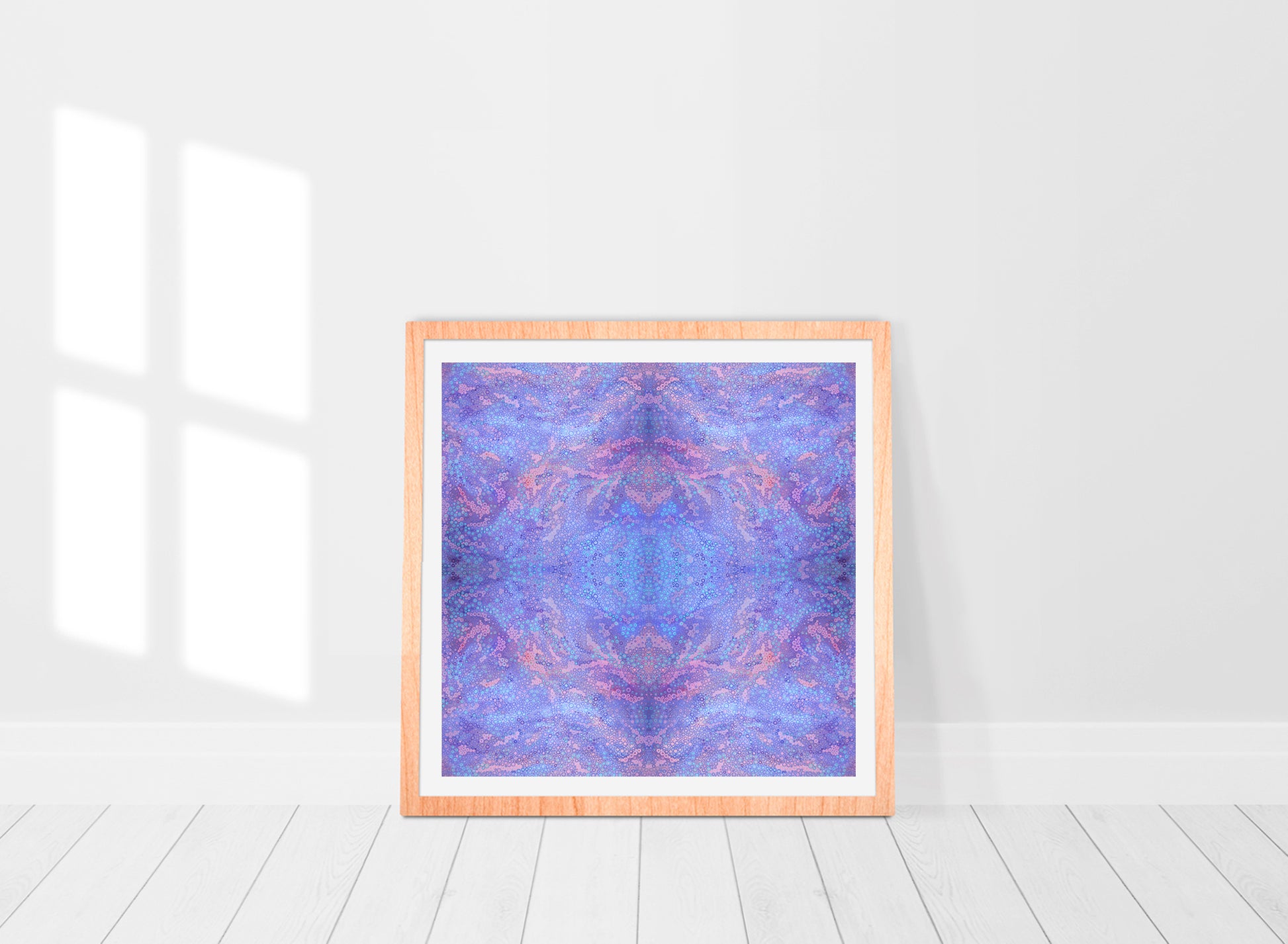 purple mandala print comprised of hundreds of dots and circles in various sizes in a frame in a room