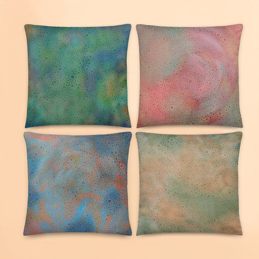 Set of four tropical abstract cushion covers featuring layered circular artwork patterns in green, coral, blue and sandy neutral tones.