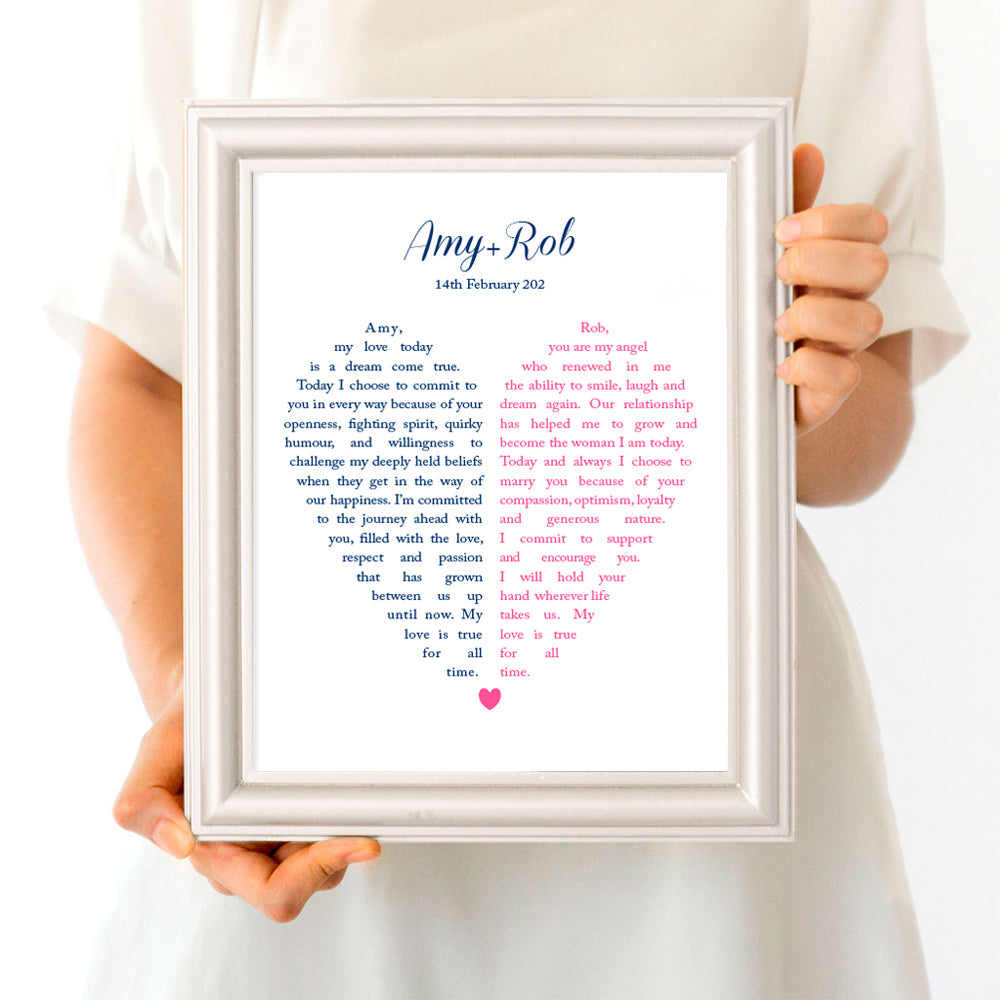 Person holding frame with wedding vows in the shape of a heart split in two
