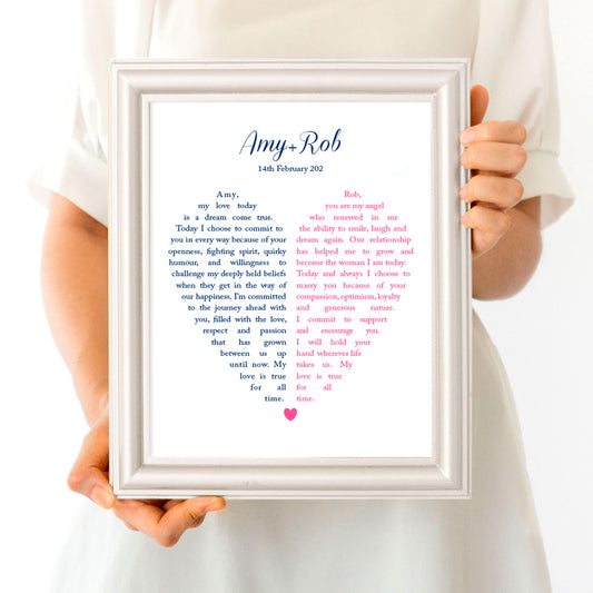 Person holding frame with wedding vows in the shape of a heart split in two