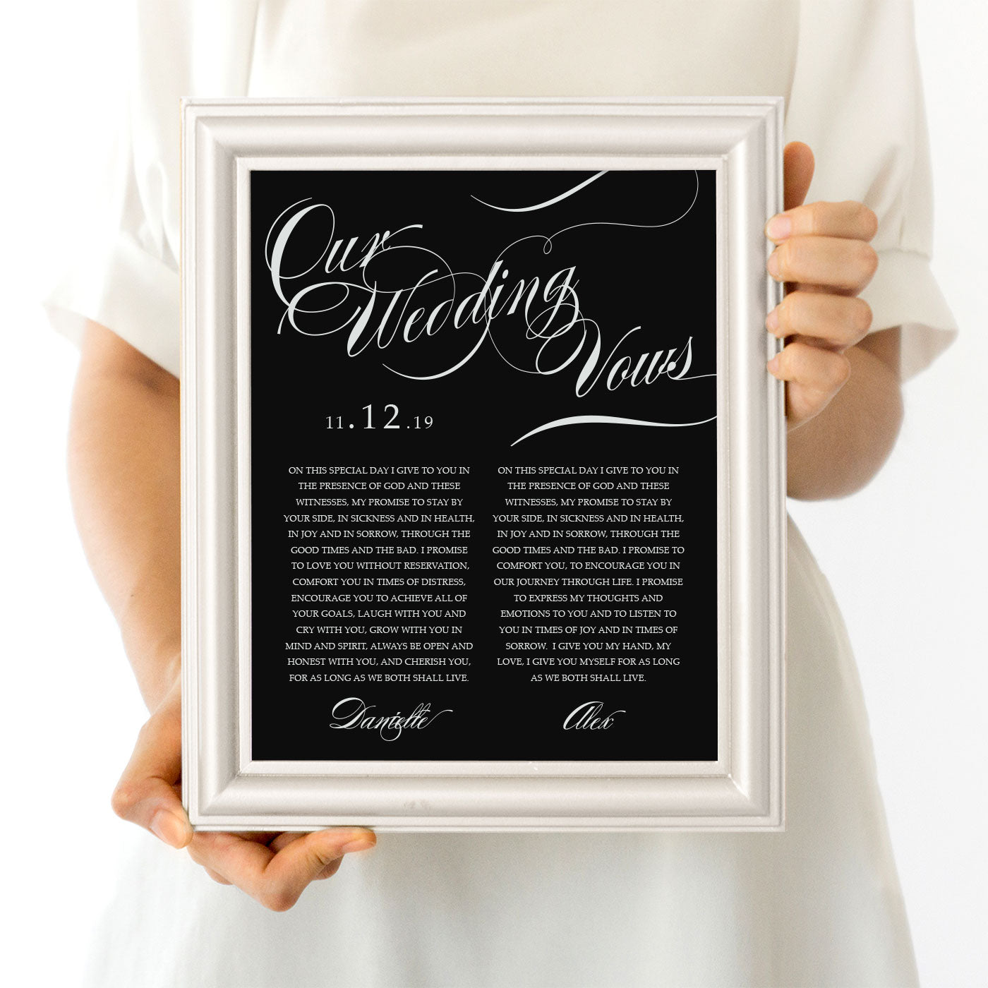 person holding frame with a wedding vow print in black and white