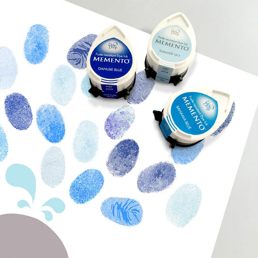 set of three blue ink pads sitting on fingerprint guest book 